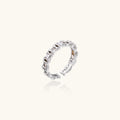 White gold plated ring with architectural lattice design and zirconia accents on cream background