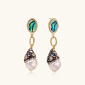 Gold drop earrings with iridescent abalone studs, rope links, jeweled caps and white baroque pearls on cream background