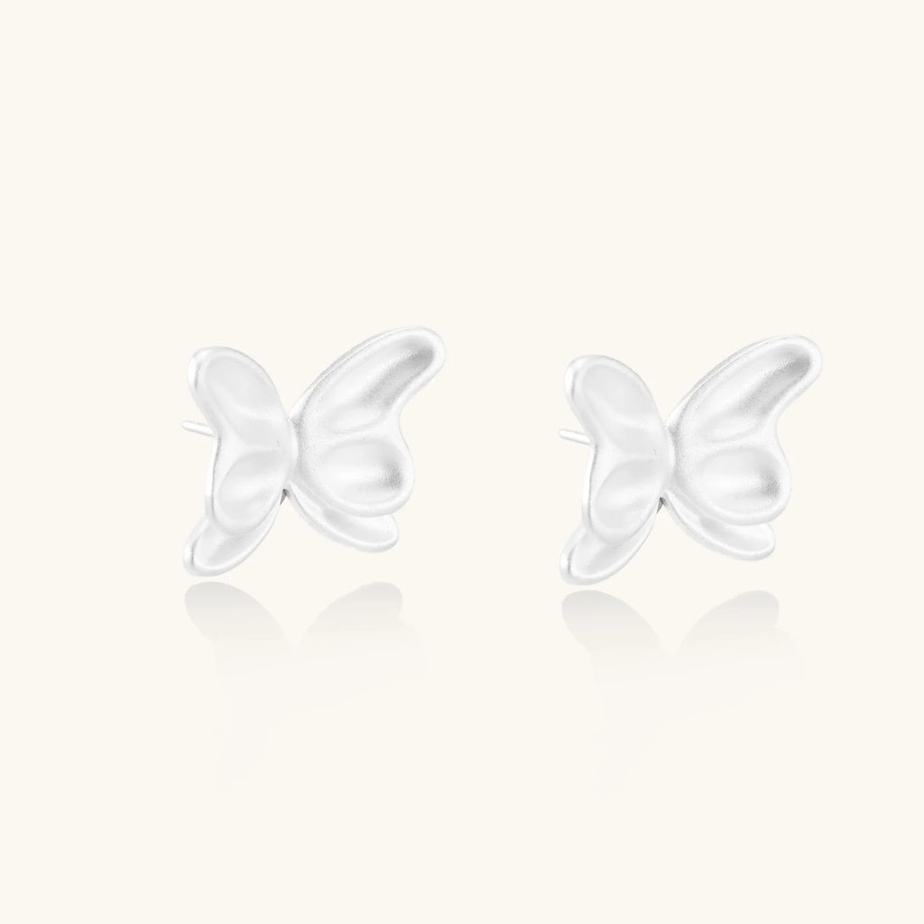 Pair of translucent butterfly-shaped stud earrings with frosted finish and dimensional wing details on white background