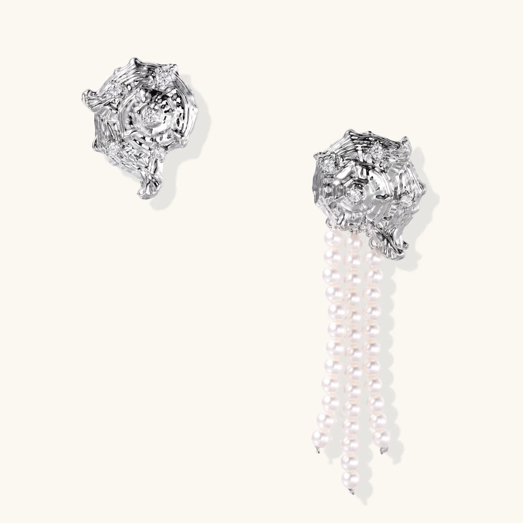 Silver-toned sculptural panther head earrings with zirconia details and white pearl drops on cream background