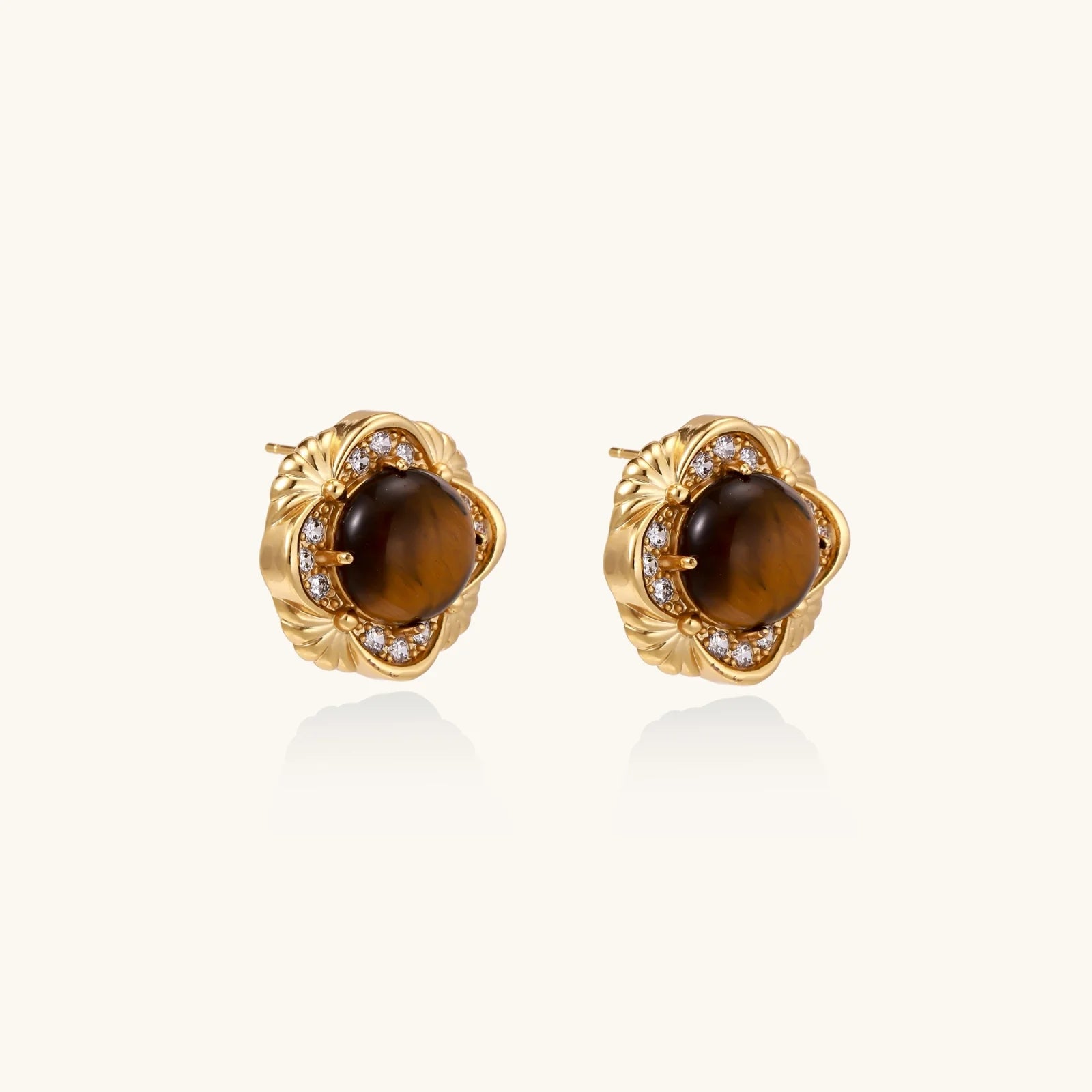 Gold-plated stud earrings with ornate floral frames surrounding cabochon tiger's eye stones and zirconia accents