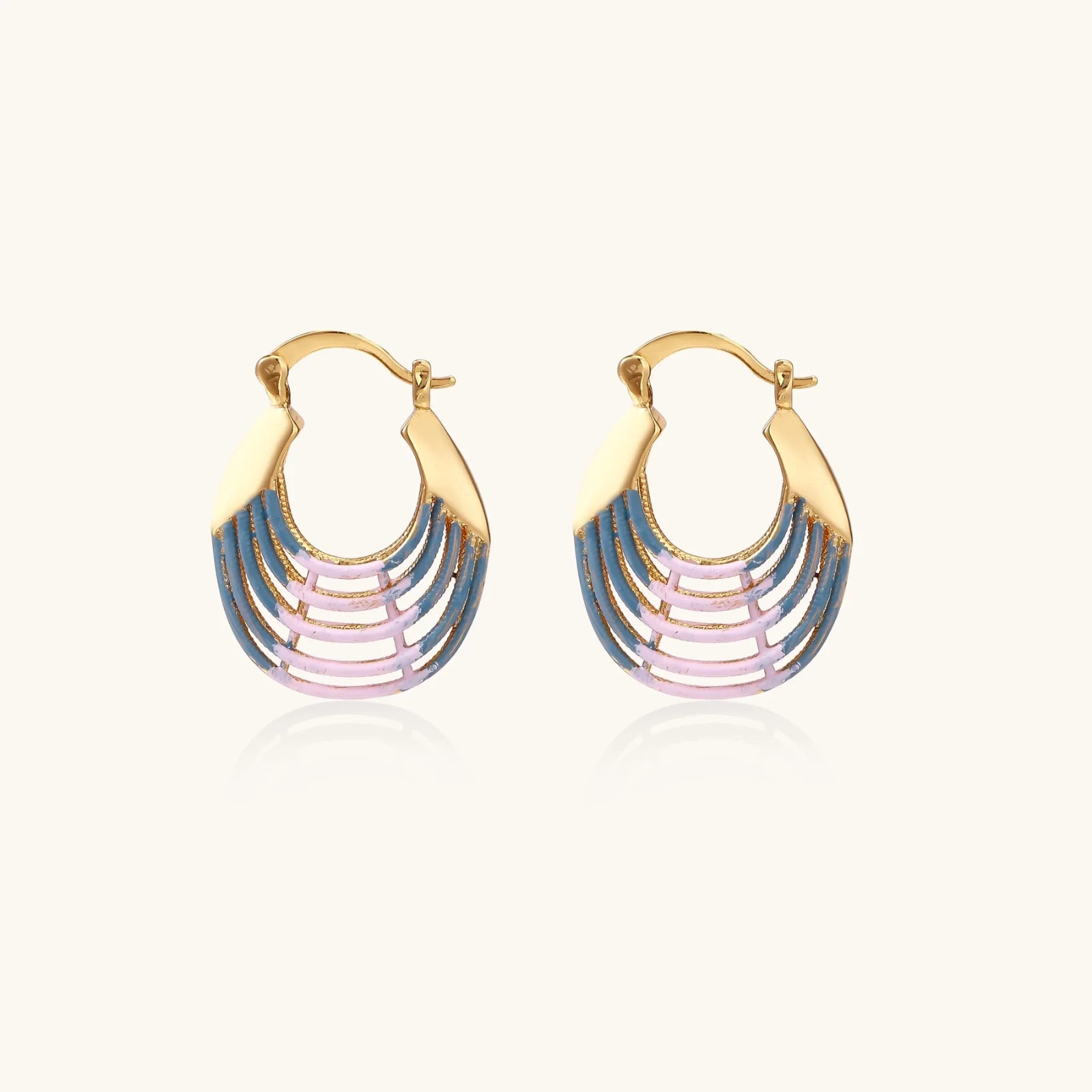 Gold hoop earrings with gradient blue-to-pink enamel in ribbed fan design on beige background