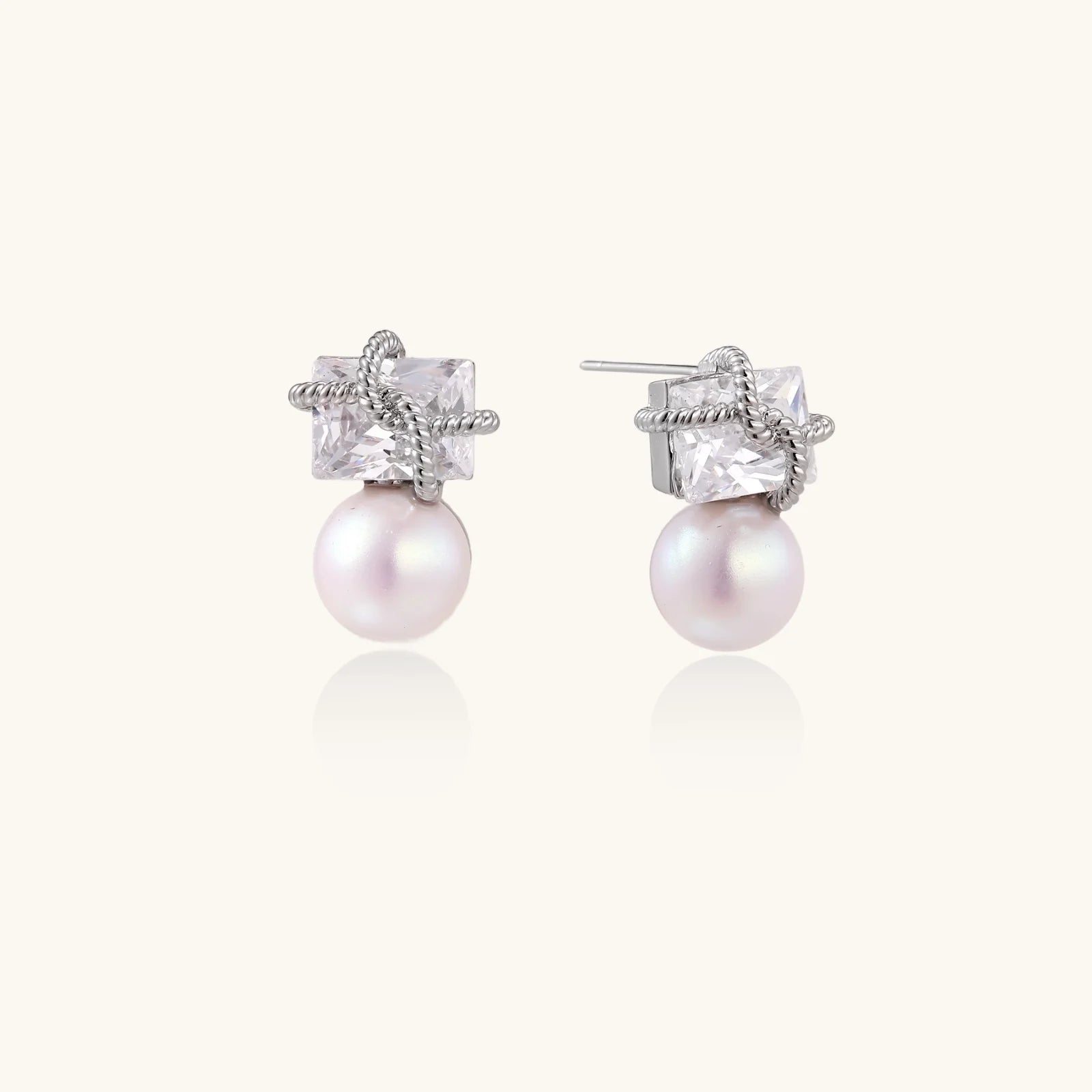 White gold stud earrings with square crystal stones in twisted frames and pink freshwater pearl drops below