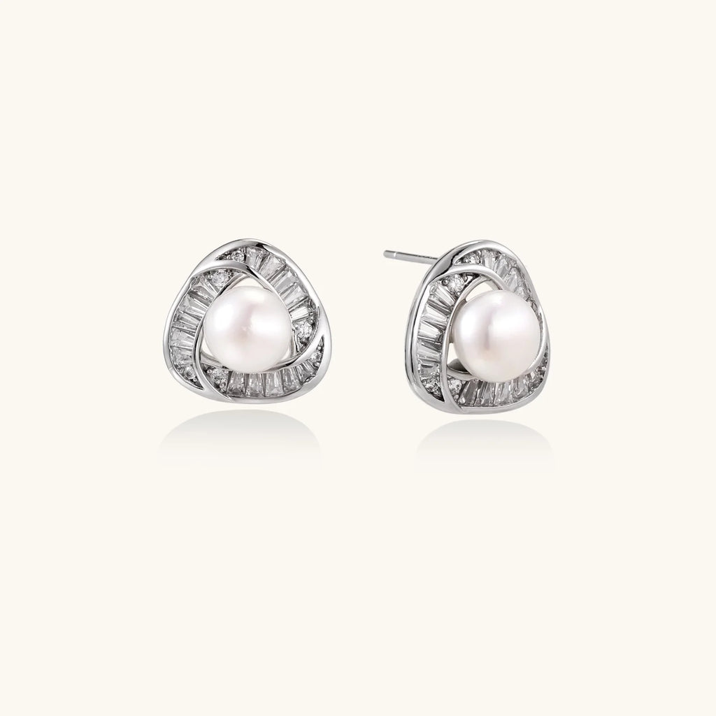 Triangular white gold plated stud earrings with central freshwater pearl and baguette-cut stones on white background