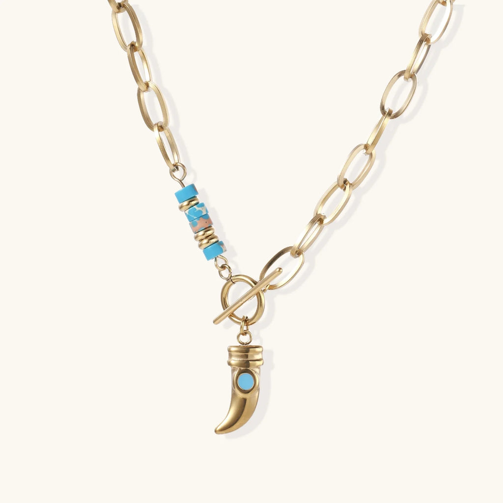 Gold chunky chain necklace with turquoise beaded accent and horn pendant on white background
